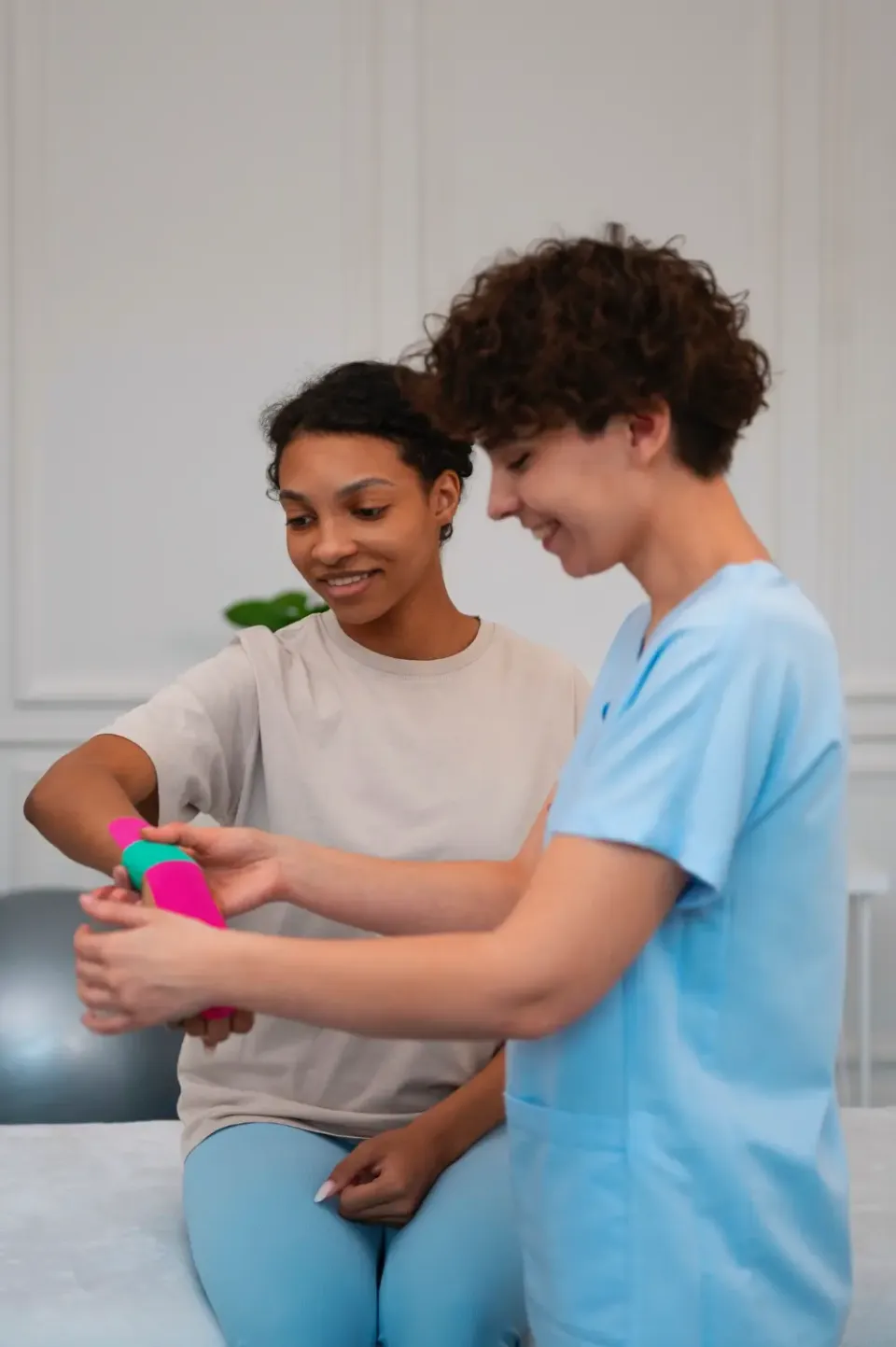Therapeutin übt mit einer Patientin Bewegungen mit einem Therapieball